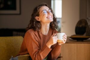 Woman smiling and enjoying coffee