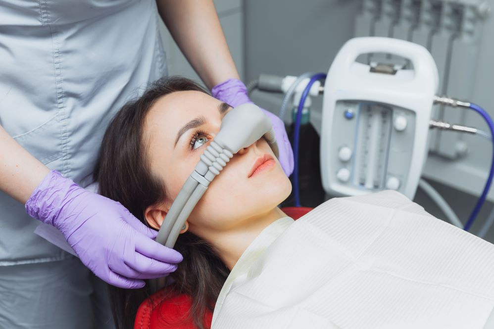 A woman in a dental chair wearing a mask for nitrous oxide sedation