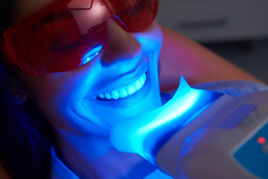 Woman having teeth whitened at dental office